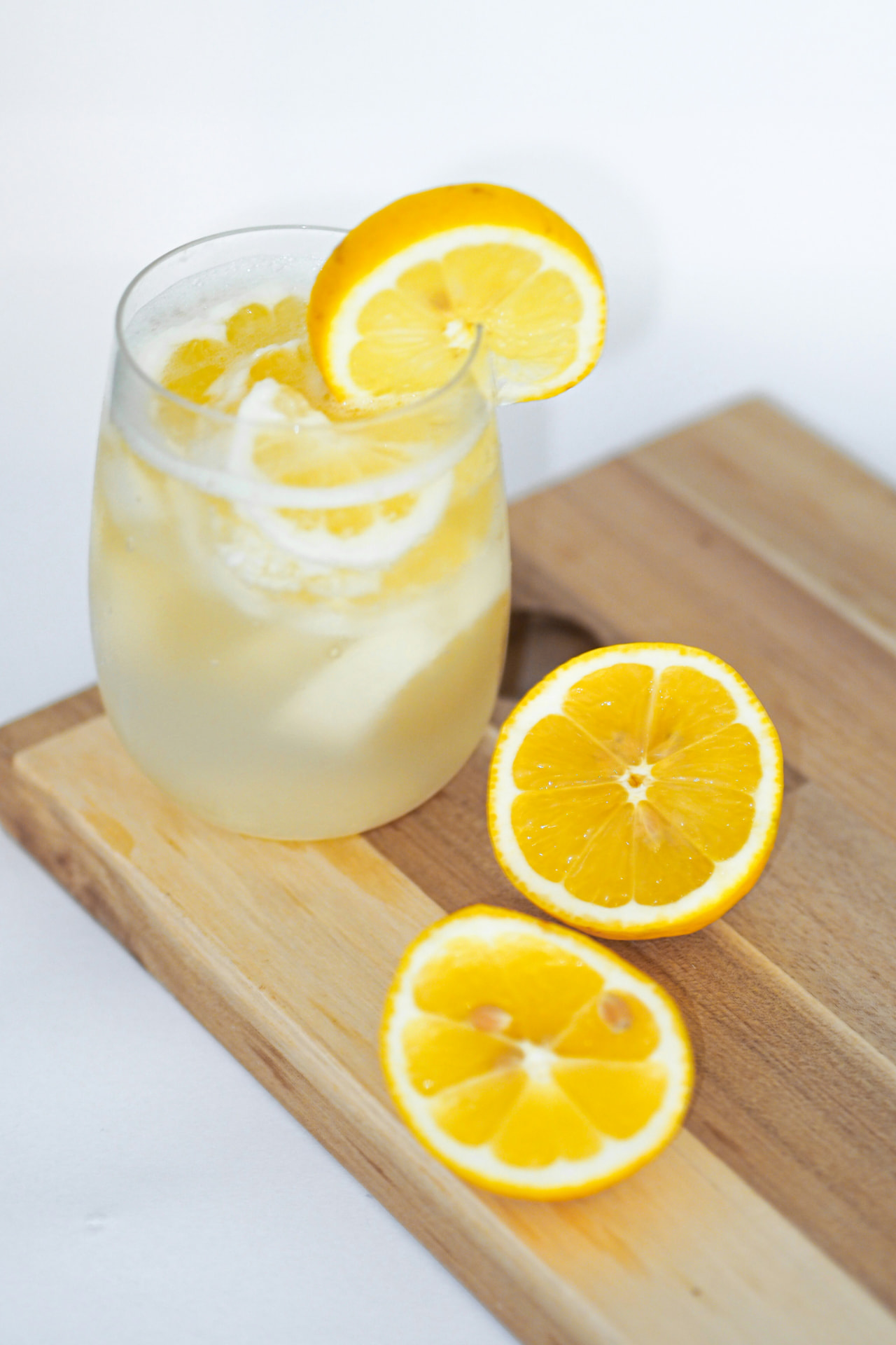 A glass of fresh lemonade with lemon slices on a wooden board — the lemonade stand of an “AI-powered” wrapper startup, PaxRocket blog