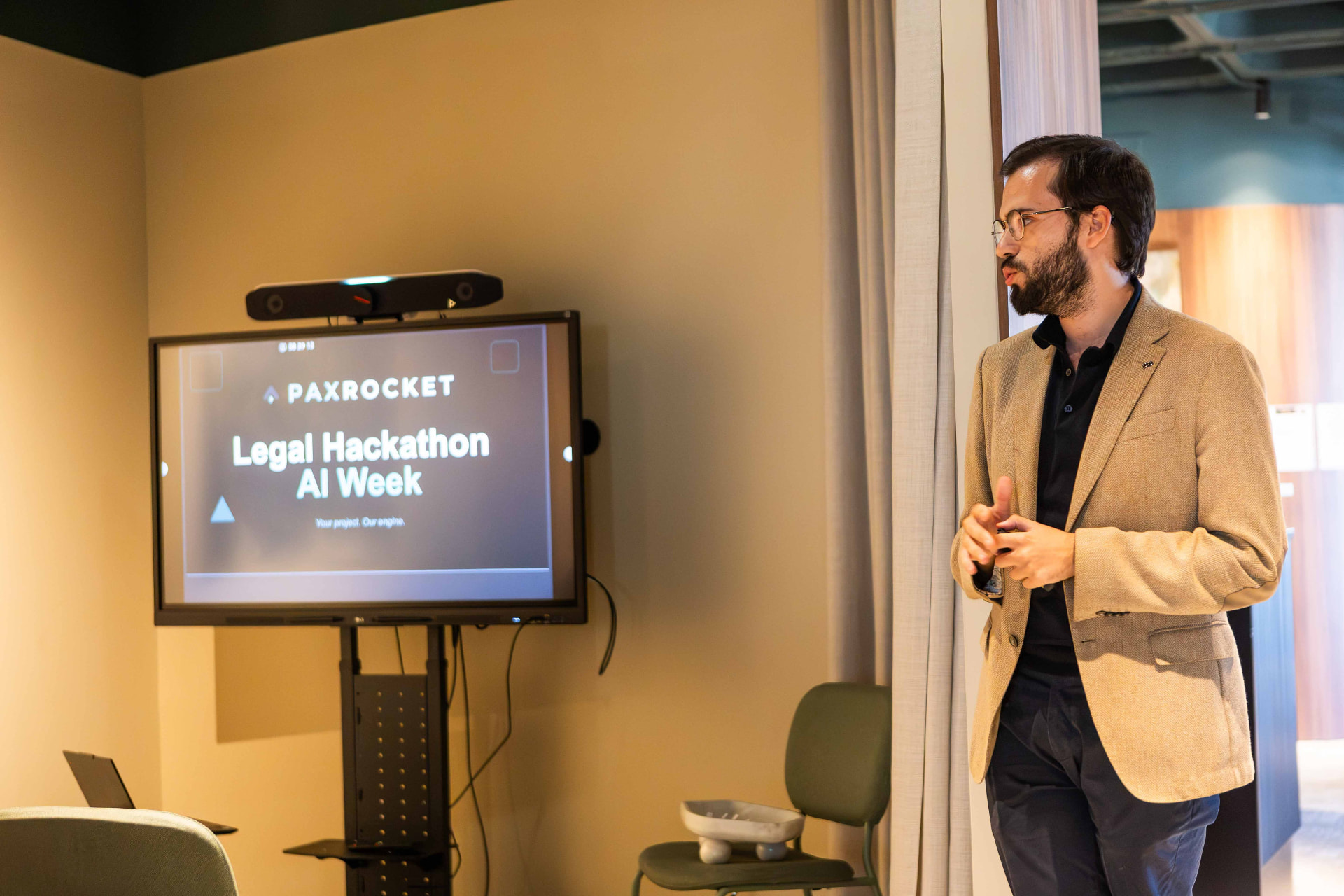 Host opening the LegalTech Hackathon at PaxRocket in front of the event title screen.